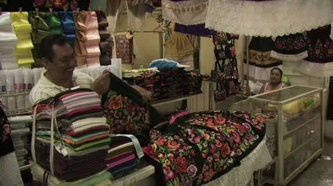 A Merchant Folding and Preparing Fabrics For Sale At A Marketplace in Mexico 스톡 동영상 19328024