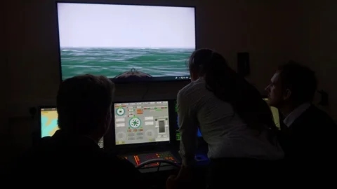 Merchant navy officers view the graphics and navigational aids on the Stock Footage 107092376