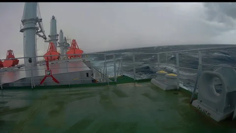 Merchant vessel with cranes going through the ocean in bad weather Stock Footage 165423197