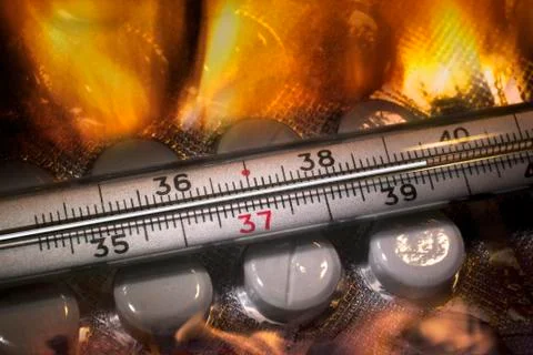 Mercury thermometer and tablets in fire Stock Photos