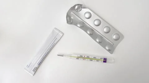Mercury thermometer showing a high temperature with an empty pill blister p.. Vídeos de archivo 335141544