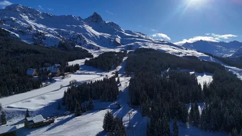 Meribel Alpine Chalets Snow Forest Sun Flare Aerial Drone Video Winter 4K 動画素材 335921647