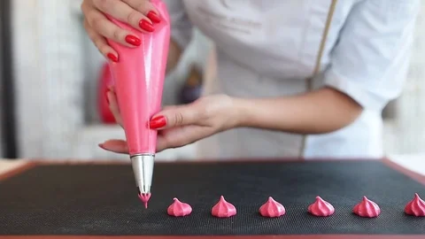 The meringue is squeezed out onto the baking tray before baking. pink meringue. Stock Footage 79593973