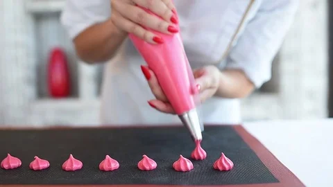 The meringue is squeezed out onto the baking tray before baking. pink meringue. Stock Footage 79594154