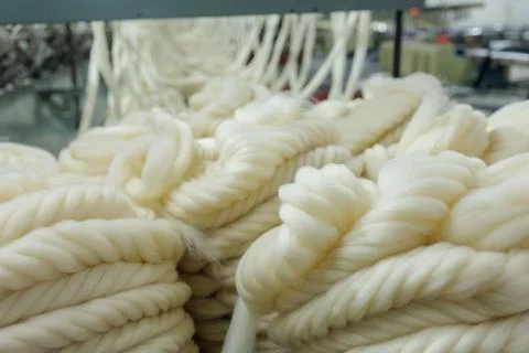 Merino wool slivers twisted into thick yarn in spinning mill Stock Photos