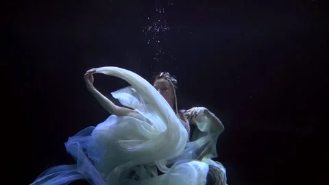 Mermaid is floating in deepness of ocean in night, slow motion shot 動画素材 168368480