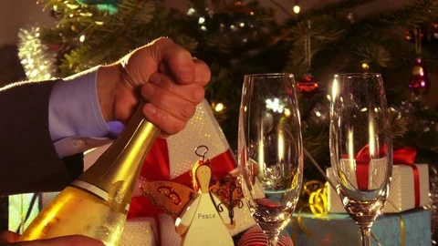 Merry Christmas - A man opens a bottle of sparkling wine - 4 k Stock Footage 76686030