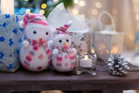 Merry Christmas present box, two snowman toys and white candle. Stock Photos