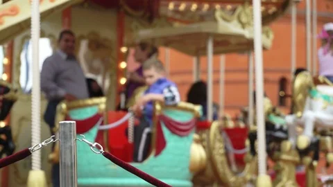 Merry-go-round carousel. Happy kids with parents riding carousel and taking Stock Footage 83465856