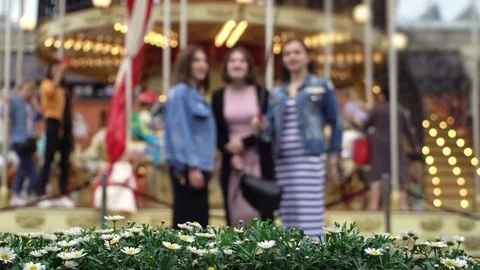 Merry-go-round carousel. Three cheerful young girls makes selfie in background Stock Footage 81188797