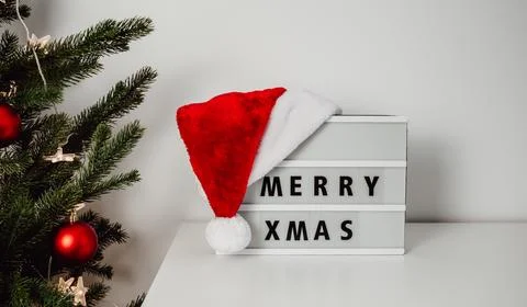 Merry xmas text on light box near fir tree. christmas background Stock Photos