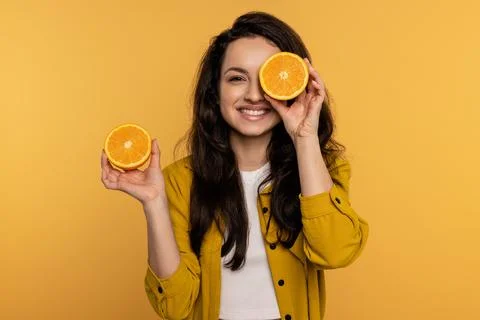 Merry young lady posing for the camera with citrus fruit halves against the Stock Photos
