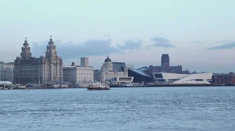 Mersey ferry crosses in front of liverpool skyline at dusk Stock Footage