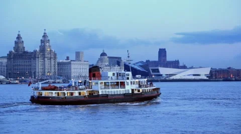 Mersey ferry crosses in front of liverpool skyline at dusk Stock Footage