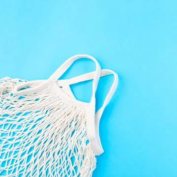 Mesh bag on a blue background, zero waste or plastic free concept, top view 스톡 사진