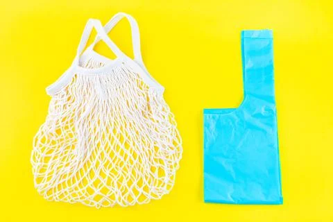 Mesh bag vs plastic bag on a yellow background, zero waste or plastic free Foto stock
