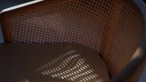 Mesh wooden chair on the sun rays Stock Footage 280693389