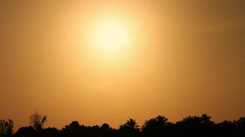A mesmerizing 4K time-lapse of the golden sun moving across a warm orange sky. Stock Footage 293118905