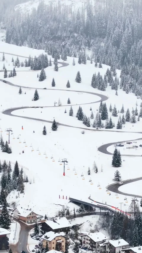 A mesmerizing aerial view captures the motion of cars winding through a sno.. 库存影片 339445743
