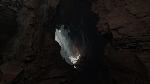 A mesmerizing cave with a ray of sunlight streaming through a small opening Stock Footage 253819654