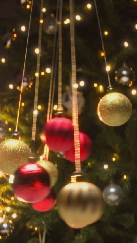 Mesmerizing Christmas Balls Pendulums Swing in Front of the Tree Stock Footage 322974908