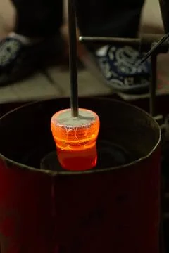 A mesmerizing close-up of a skilled artisan blowing molten glass into shape Photos