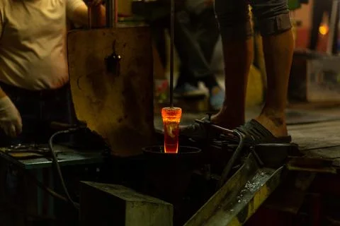 A mesmerizing close-up of a skilled artisan blowing molten glass into shape Fotos de archivo