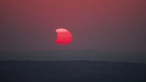 A mesmerizing close-up timelapse of solar eclipse at sunset, captured in Sud Stock Footage 343007273