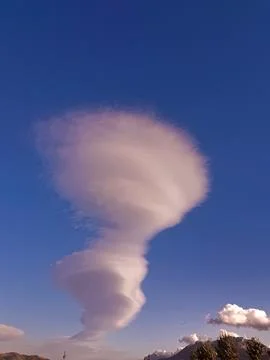 Mesmerizing cloud formation that appears to defy the tranquility of clear sky Stock Photos