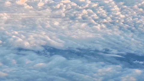 The mesmerizing cloud patterns in the sky captured from an airplane window .. Stock Photos