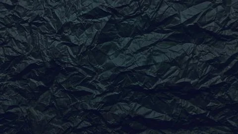 Mesmerizing crumpled black paper texture with dramatic deep folds and moody.. Stock Photos