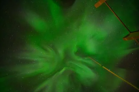 A mesmerizing display of green aurora lights fills the night sky, creating .. Stock Photos