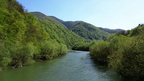 A mesmerizing drone flyover capturing the beauty of a fast-flowing river cutting Stock Footage 299711159
