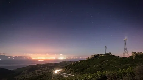 Mesmerizing evening with windmills and car rushing over the mountain road Stock Footage 77549249