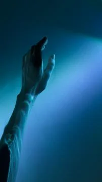 A Mesmerizing Exploration of Light and Shadow: A Hand Reaching Out Towards a Stock Photos