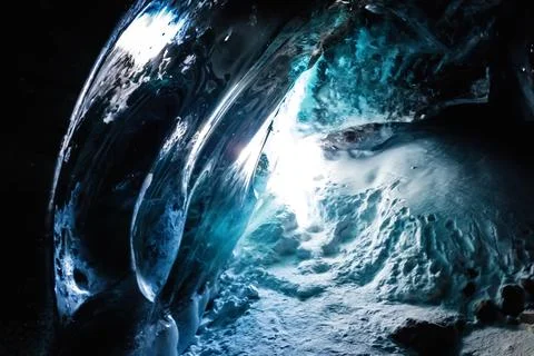 Mesmerizing ice cave amidst the dark landscape of the Bogdanovich Glacier in the Stock Photos