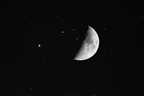 A mesmerizing scenery of the moon surrounded by shiny stars in the magical ni Stock Photos