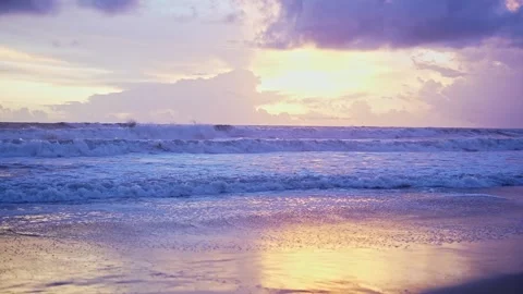 Mesmerizing sea waves ripple gently toward the sandy shore under a golden e.. Stock Footage 313381140