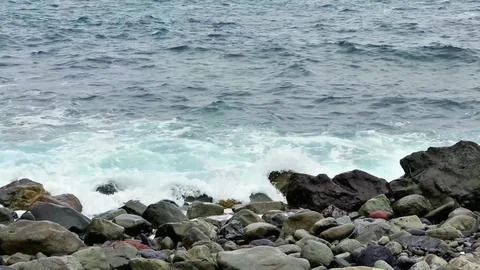 The mesmerizing sight of waves crashing powerfully against a rocky shorelin.. Stockfoto's