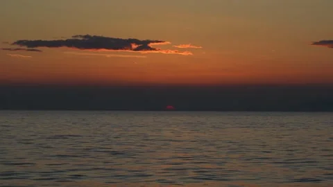Mesmerizing sunset over calm sea horizon with vivid orange hues in the sky Stock Footage 299896889