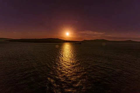 A mesmerizing sunset at Santorini casts golden reflections over the Aegean Sea Stock Photos
