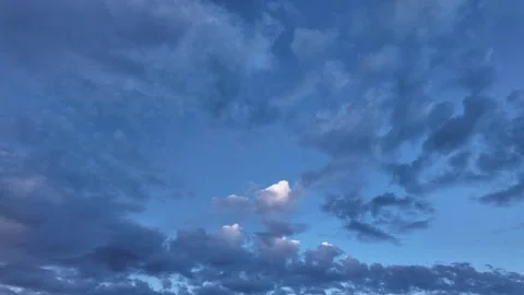 Mesmerizing timelapse of dynamic clouds drifting across a serene deep blue sky Stock Footage 314962891