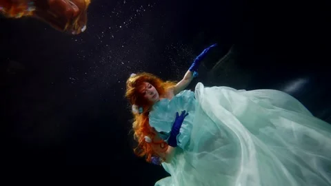 Mesmerizing underwater queen swimming alone in dark mysterious depth, reflection 库存影片 244826034
