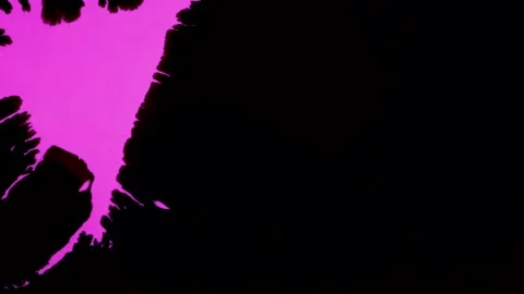 A mesmerizing video featuring a pink ink splash on a black background and a Video stock 295857363