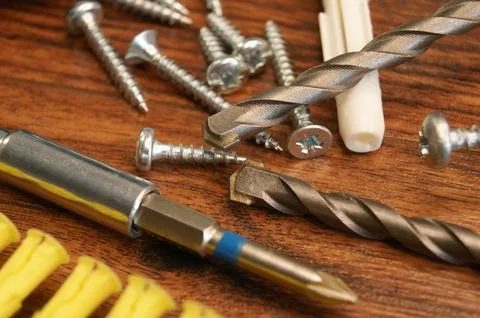 A mess in the assembly work process on the table. Dowels, screws, drill bits. Stock Photos