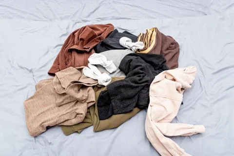 Mess pile of clothes on bed, sorting cloth in closet and making special place Stockfoto's