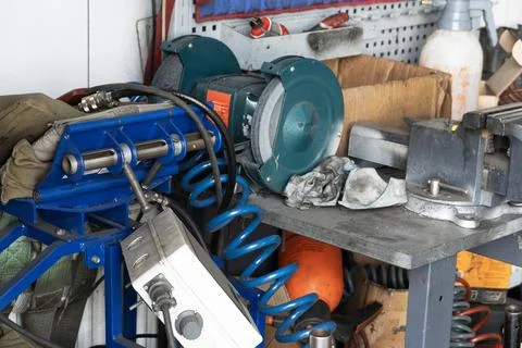 Mess on a working table with metallic tools and metal vice Stock Photos