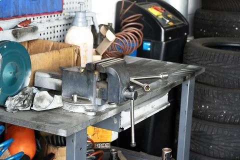 Mess on a working table with metallic tools and metal vice Stock Photos