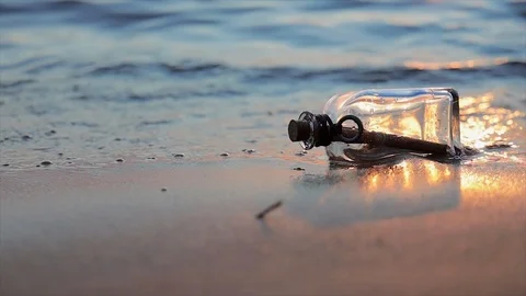Message in the bottle against the Sun setting down Stock Footage 113956748