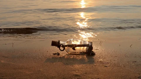 Message in the bottle against the Sun setting down Stock Footage 129174104
